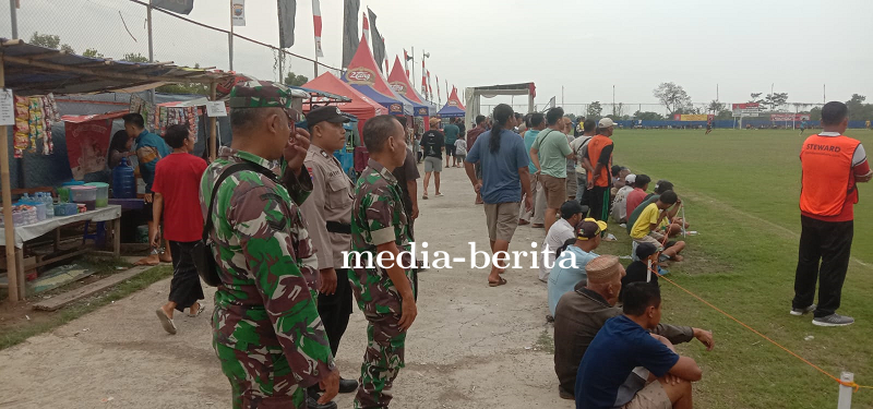 Sinergitas Babinsa Dan Bhabinkamtibmas Laksanakan Pengamanan Turnamen Sepak Bola